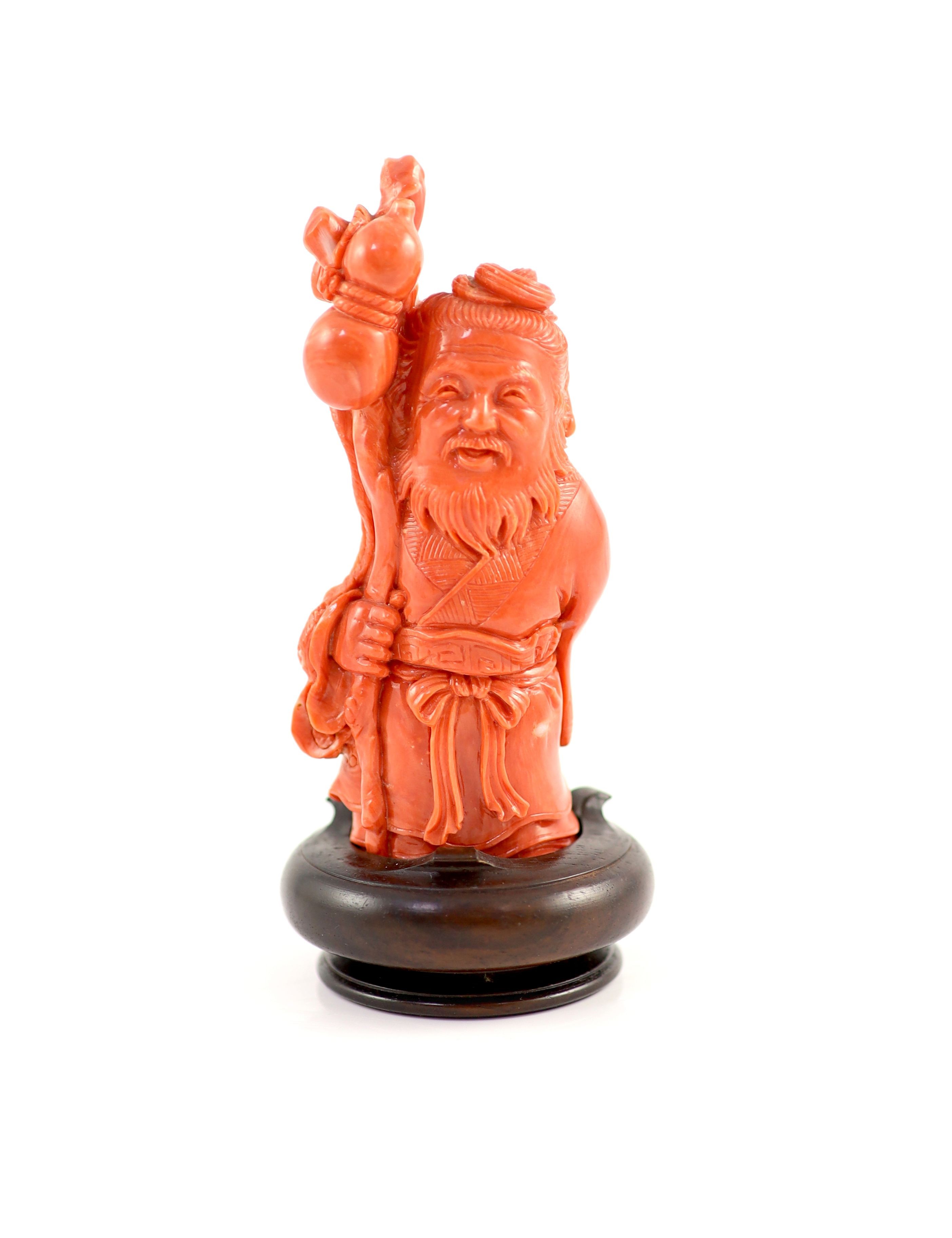 A Chinese coral standing figure of Shou Lao, mid 20th century, 11 cm high, 187g, wood stand